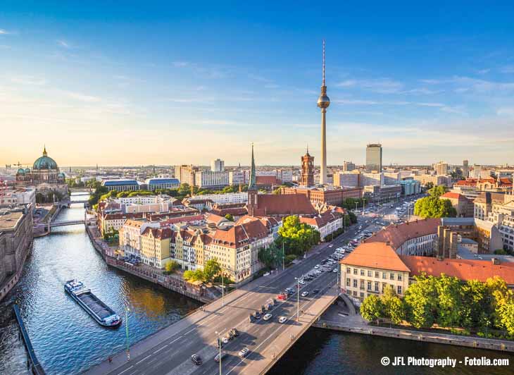 Blick auf Berlin mit Straßen und Häusern und dem Fernsehturm im Hintergrund.