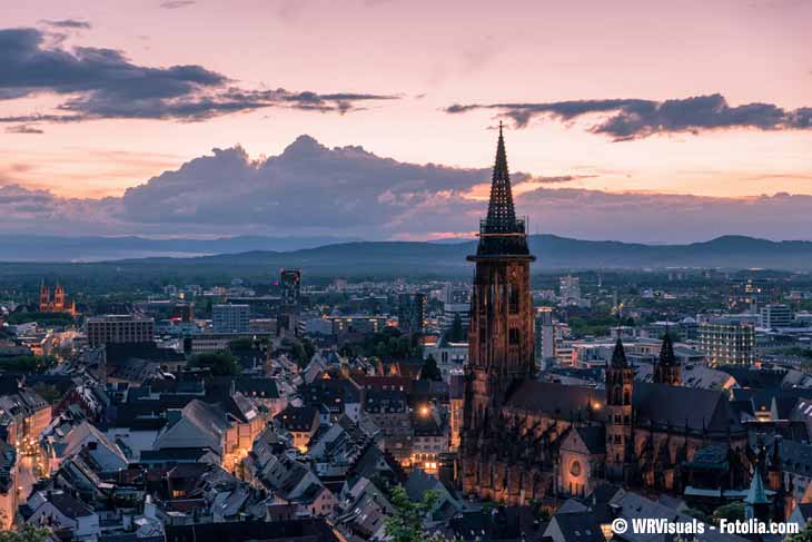 Blick von oben auf die Stadt Freiburg und das Münster bei Dämmerung.