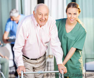 Pflegekraft hilft einem alten Herren
