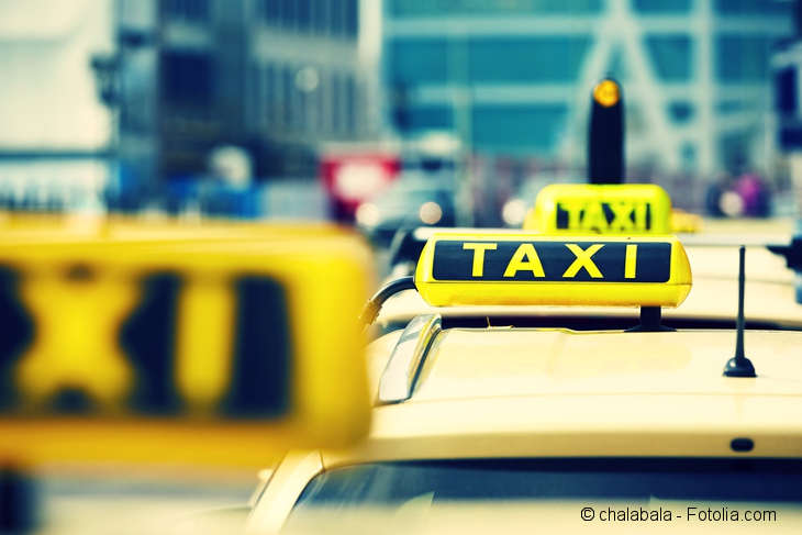 Mehrere Taxis mit leuchtenden Taxischildern