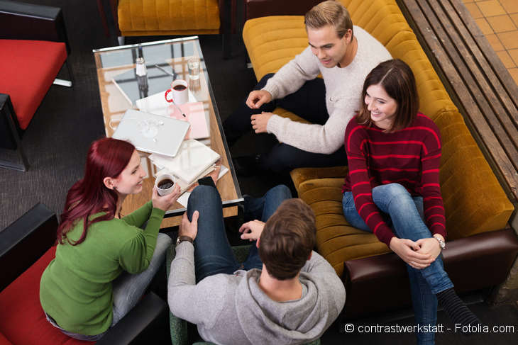 Four young people sitting and talking in the living room