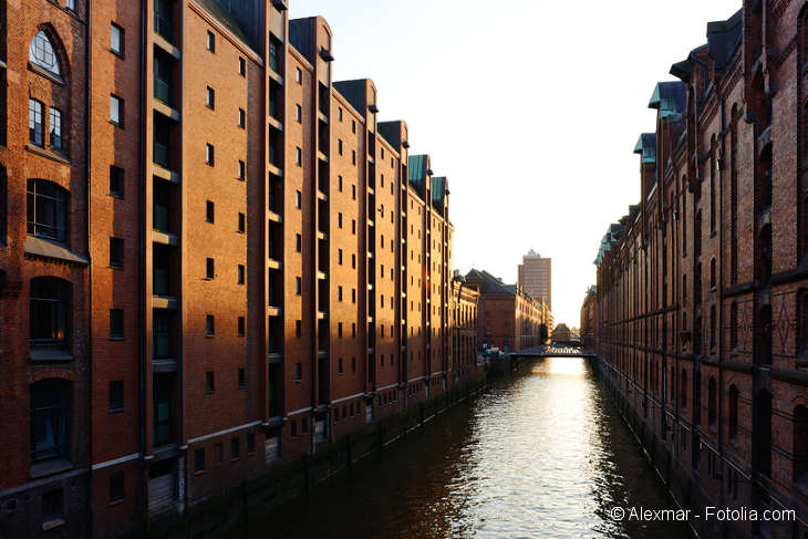 In der Mitte ein Fluss. Rechts und links Backsteinhäuserfassaden der Speicherstadt.