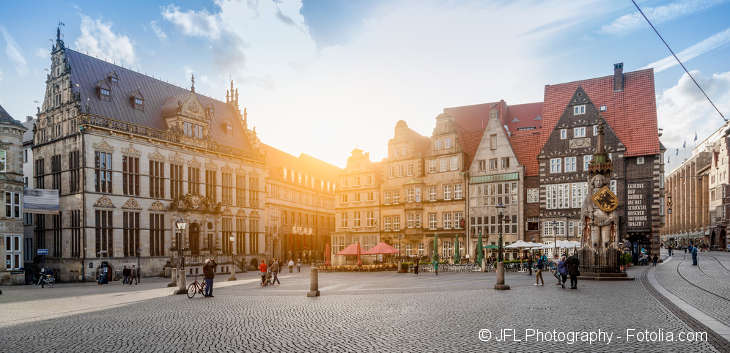 Ein Marktplatz mit stattlichen Häusern bei Sonnenuntergang.